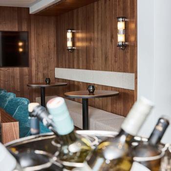 Bar & Lobby Gekühlte Weinflaschen im Eiskübel mit moderner Lounge-Sitzgruppe im Hintergrund